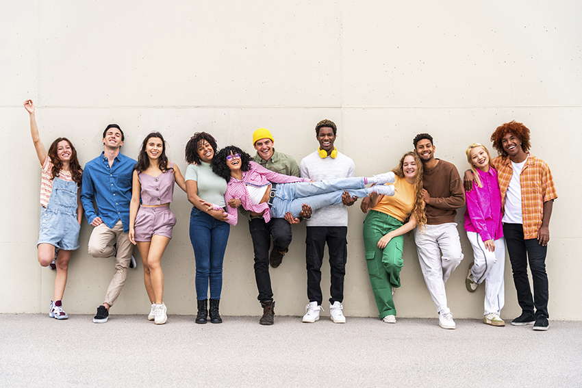 Happy playful multiethnic group of young friends bonding outdoor